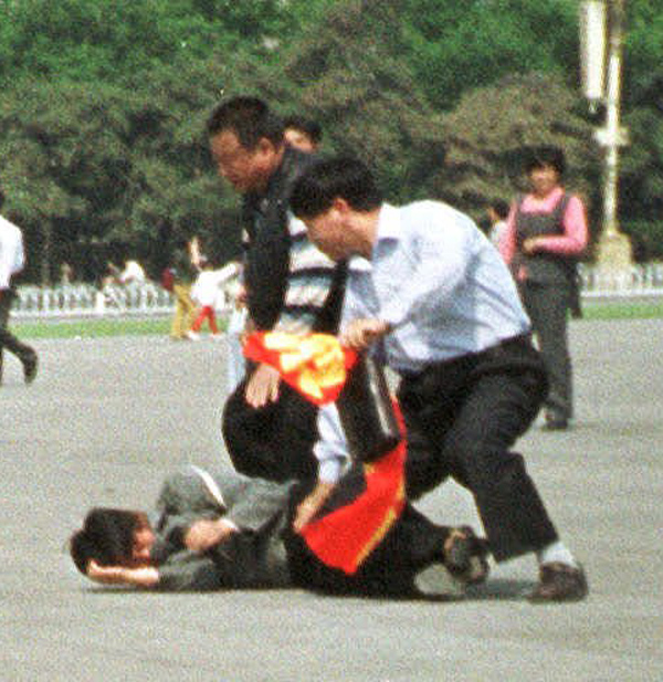 Chinese police struggle to remove a banner from a Falun Gong protester in Tianamen Square, May 13, 2000. (AP Photo/Chien-min Chung)